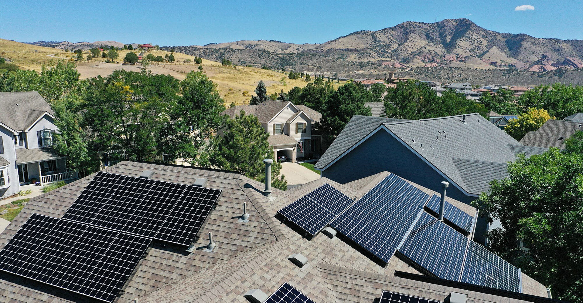 residential solar panel roofs, mountains background