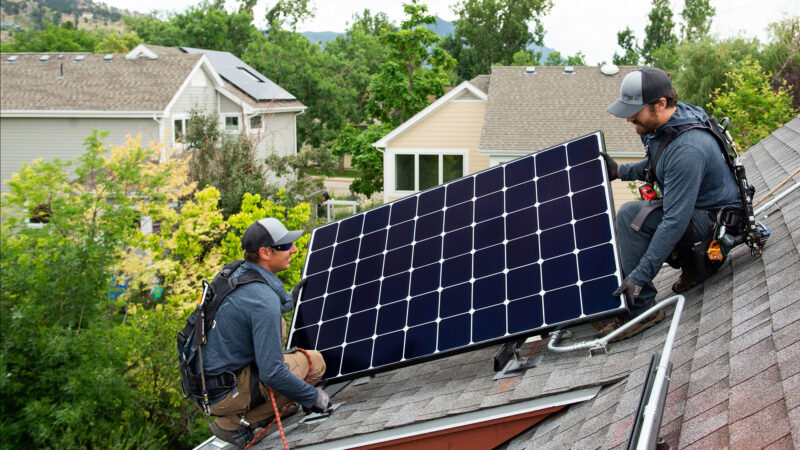 two Namaste Solar employees installing residential panel