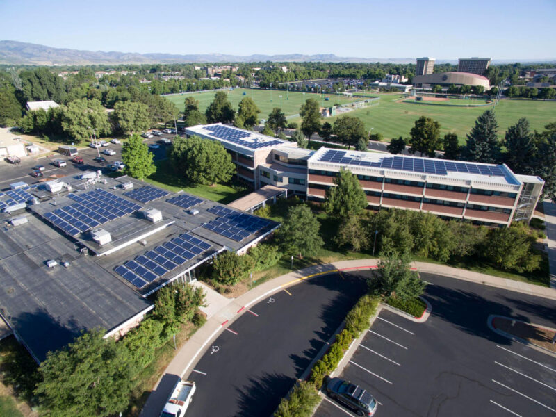 overview image of three adjacent buildings with solar panels next to a parking lot