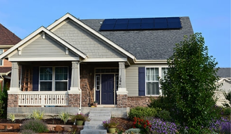 gray house with patio with solar panels on roof