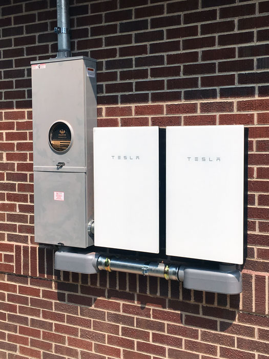 two Tesla batteries mounted on wall